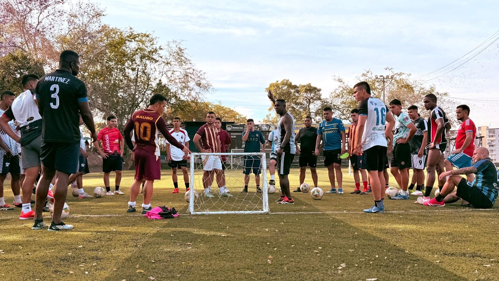 Grupo de S7 FUT recibiendo instrucciones del entrenador en la cancha