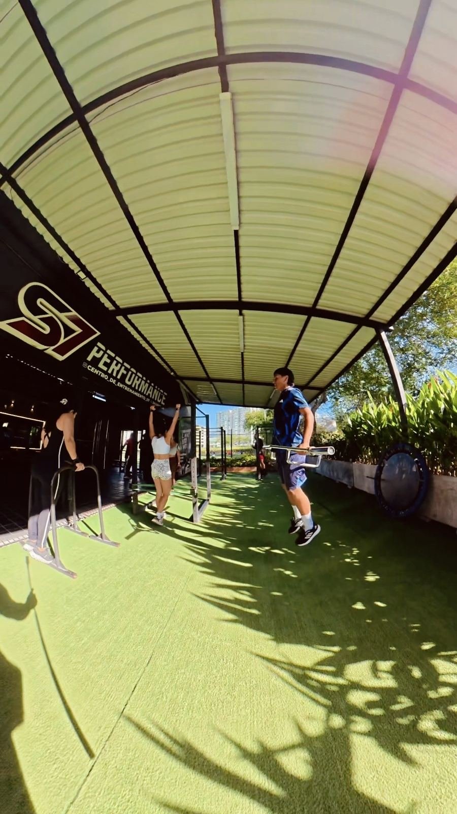Clientas haciendo dominadas en la zona exterior del gimnasio